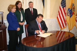 Governor Chris Christie signs his letter to President Obama requesting FEMA disaster relief this moring at the Monmouth County Hall of Records. Assembly Members Mary Pat Angelini, Caroline Casagrande and Dave Rible, background.
